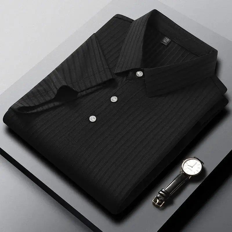 Men's black striped polo shirt, short sleeves, folded with a watch beside.