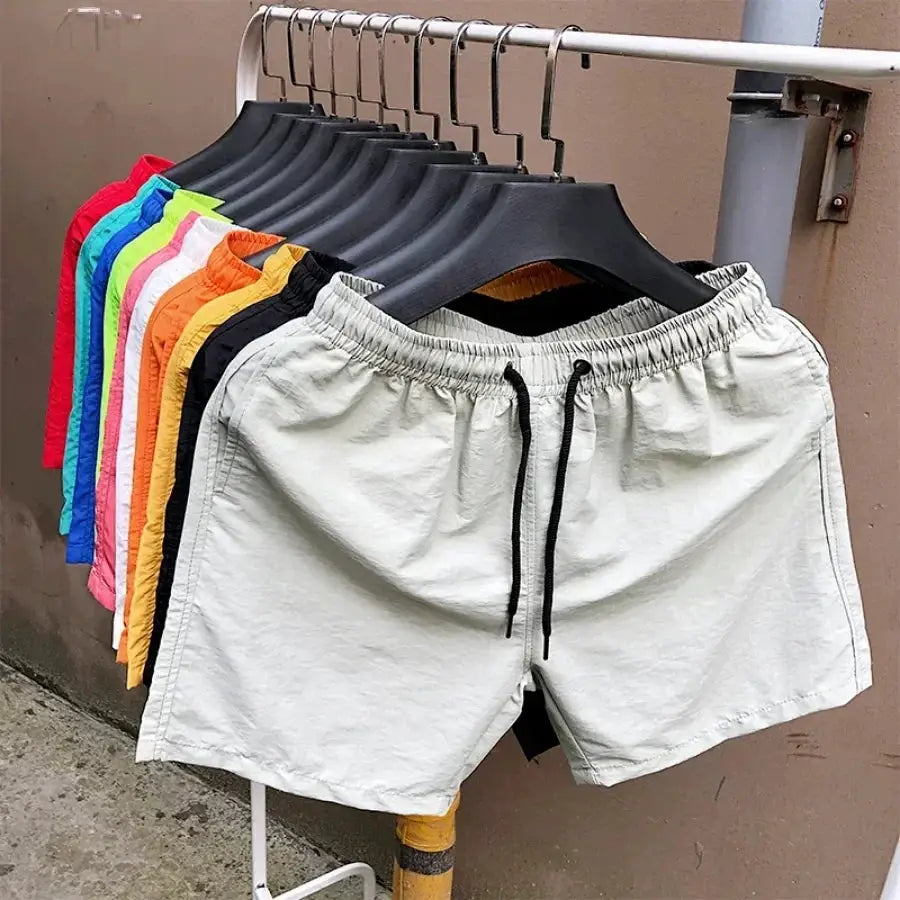 Men's swim shorts by Simples Market; light gray pair with black drawstring, with multiple color options on display