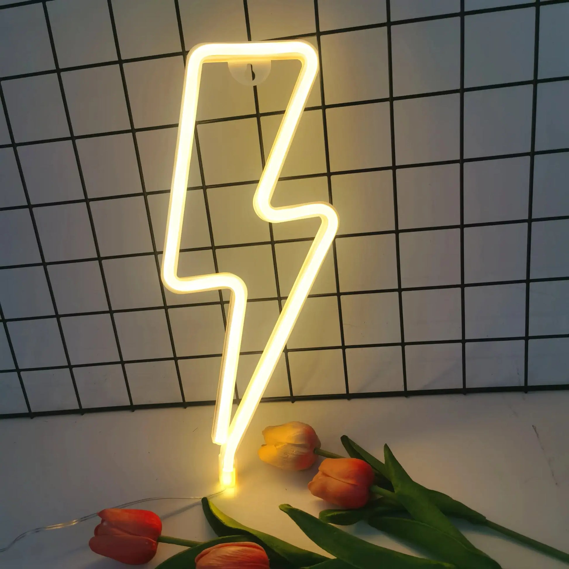 Lightning LED neon light by Simples Market, USB/battery powered, yellow glow, shown with orange tulips.