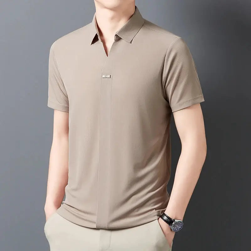 Men's beige short-sleeve polo shirt with a subtle placket and metal badge detail.