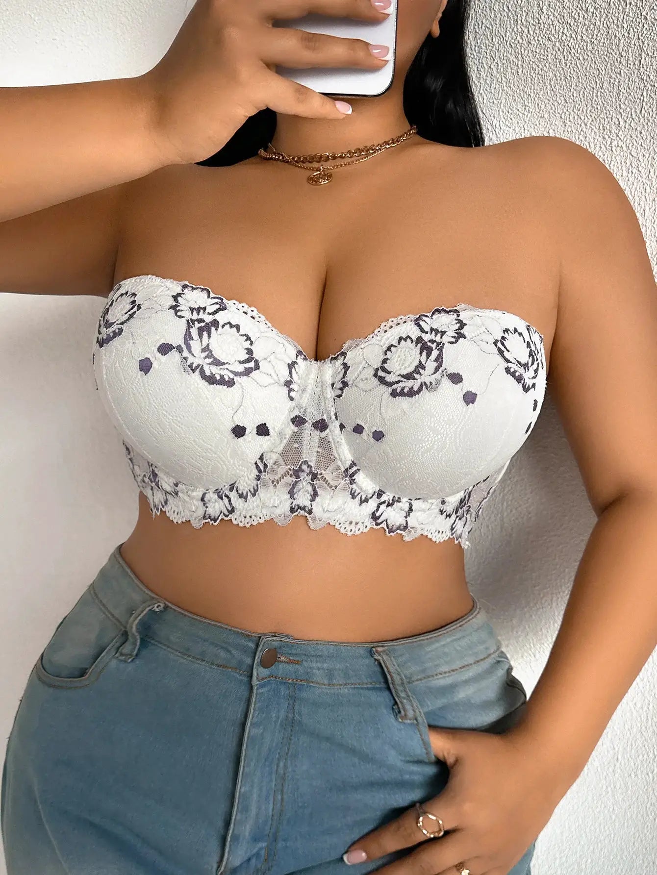 White lace bra with dark floral embroidery, underwire support, strapless push-up design and scalloped edge.