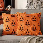 Halloween pumpkin-pattern plush pillow covers, orange with black jack-o’-lantern faces, pair on a gray sofa
