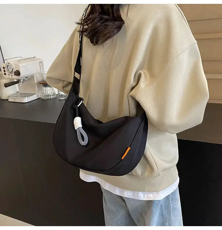 Dumpling-style crossbody bag, black fabric with wide shoulder strap for commuting