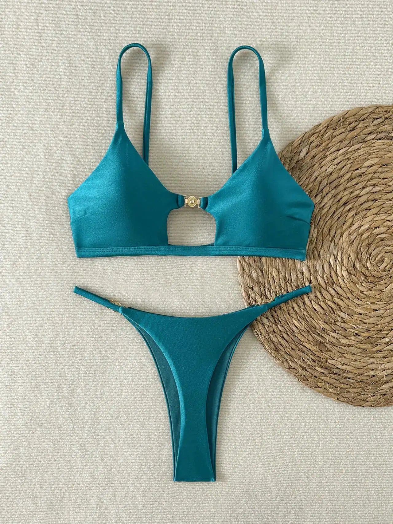 Teal shiny 2-piece bikini set with push-up triangle top and high-cut Brazilian bottoms, beside a straw hat