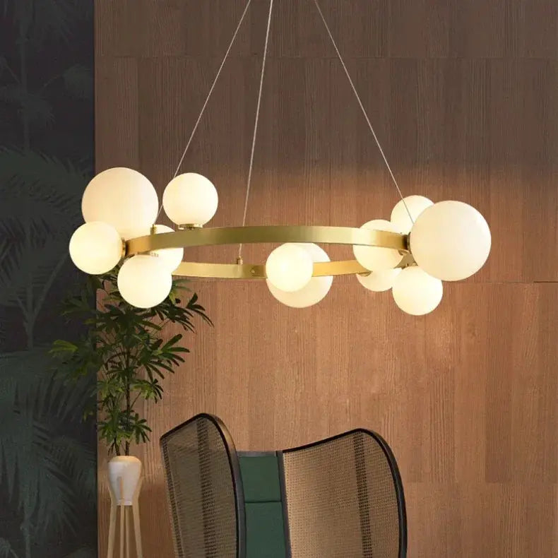 Simples Market globe chandelier in gold metal with frosted glass globes for living room.