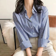 Simples Market striped blue-and-white button-down blouse with long lantern sleeves and stand collar.