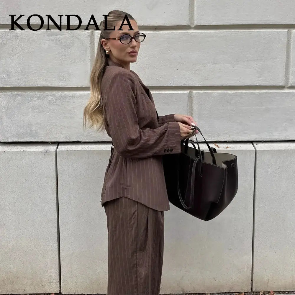 KONDALA striped brown office suit blazer with wide-leg pants worn by model carrying a dark tote bag