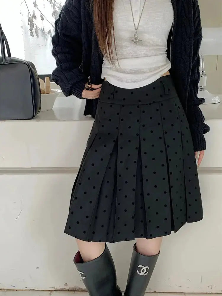 Polka dot pleated high-waist A-line knee-length black skirt from Simples Market with Chanel boots visible
