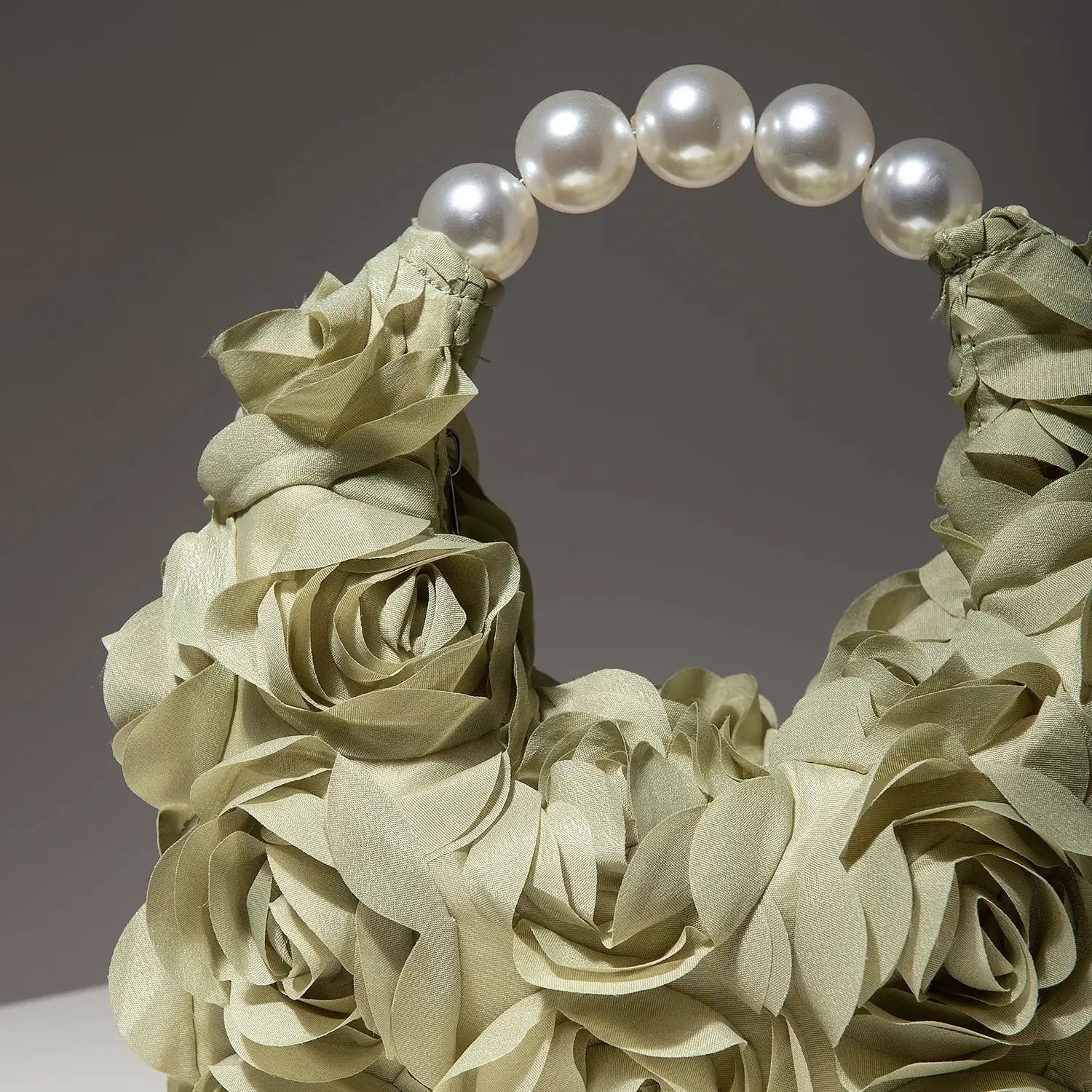 Rosette clutch in cream fabric with a pearl bead handle