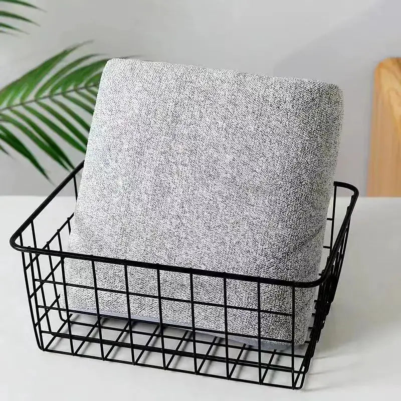 Simples Market bamboo bath towel, gray speckled, in a black wire basket.