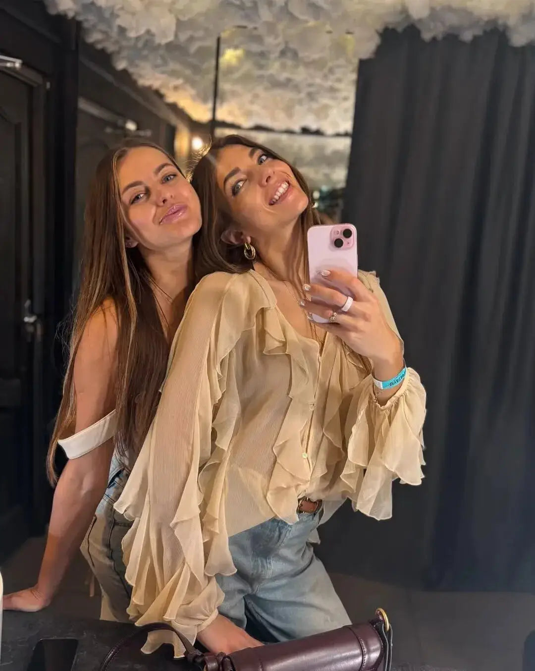Beige semi-sheer ruffle blouse with long sleeves and V-neck front button; two women posing in a mirror selfie.
