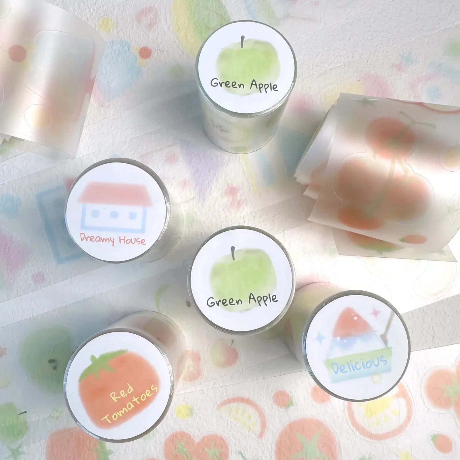 Decorative adhesive tape tins with white lids labeled Green Apple, Dreamy House, Red Tomatoes, Delicious