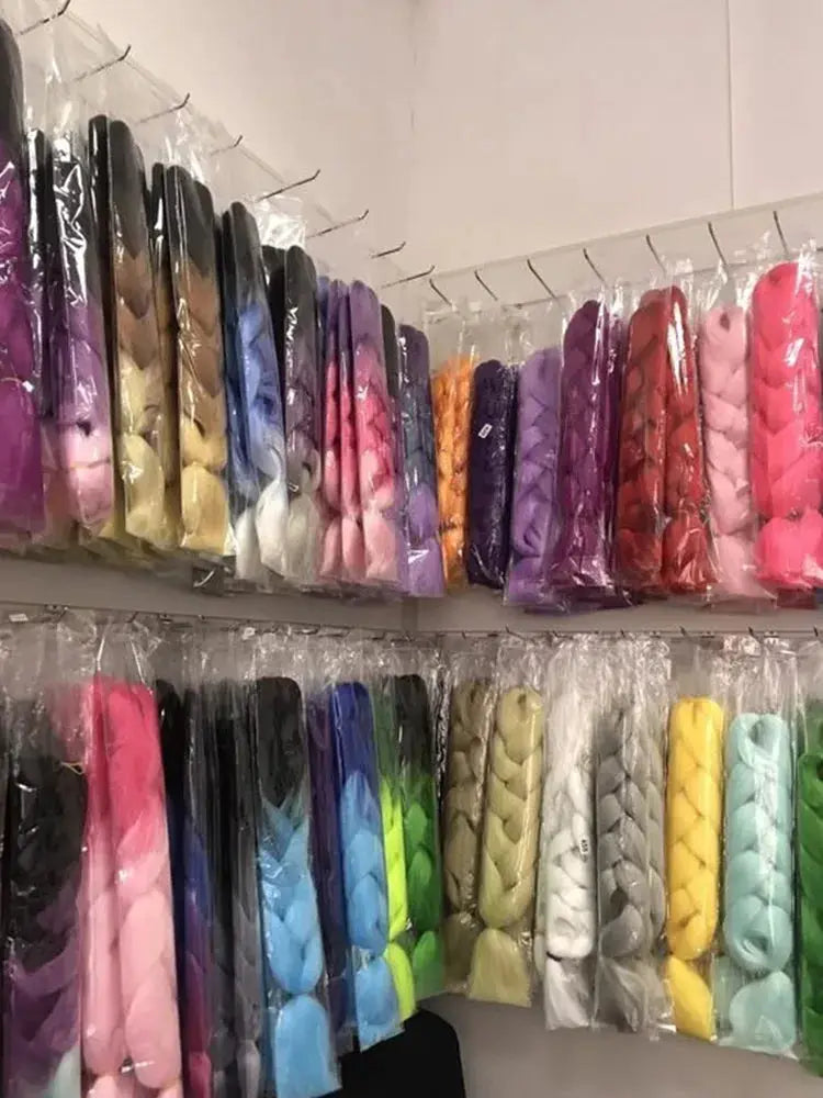 Simples Market Kanekalon crochet hair; pre-stretched jumbo curly braiding extensions in assorted colors on display.
