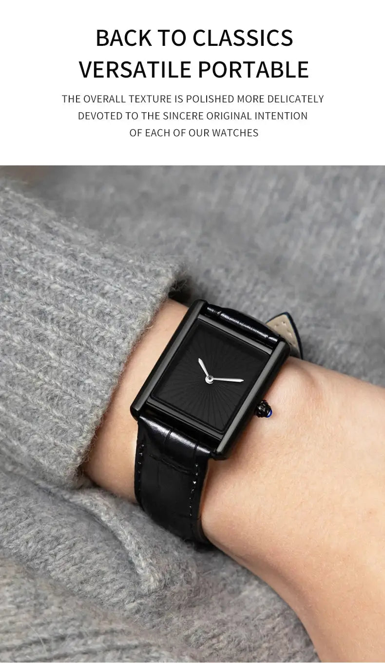 Square black wristwatch with black leather strap and minimalist white hands on a gray knit sleeve