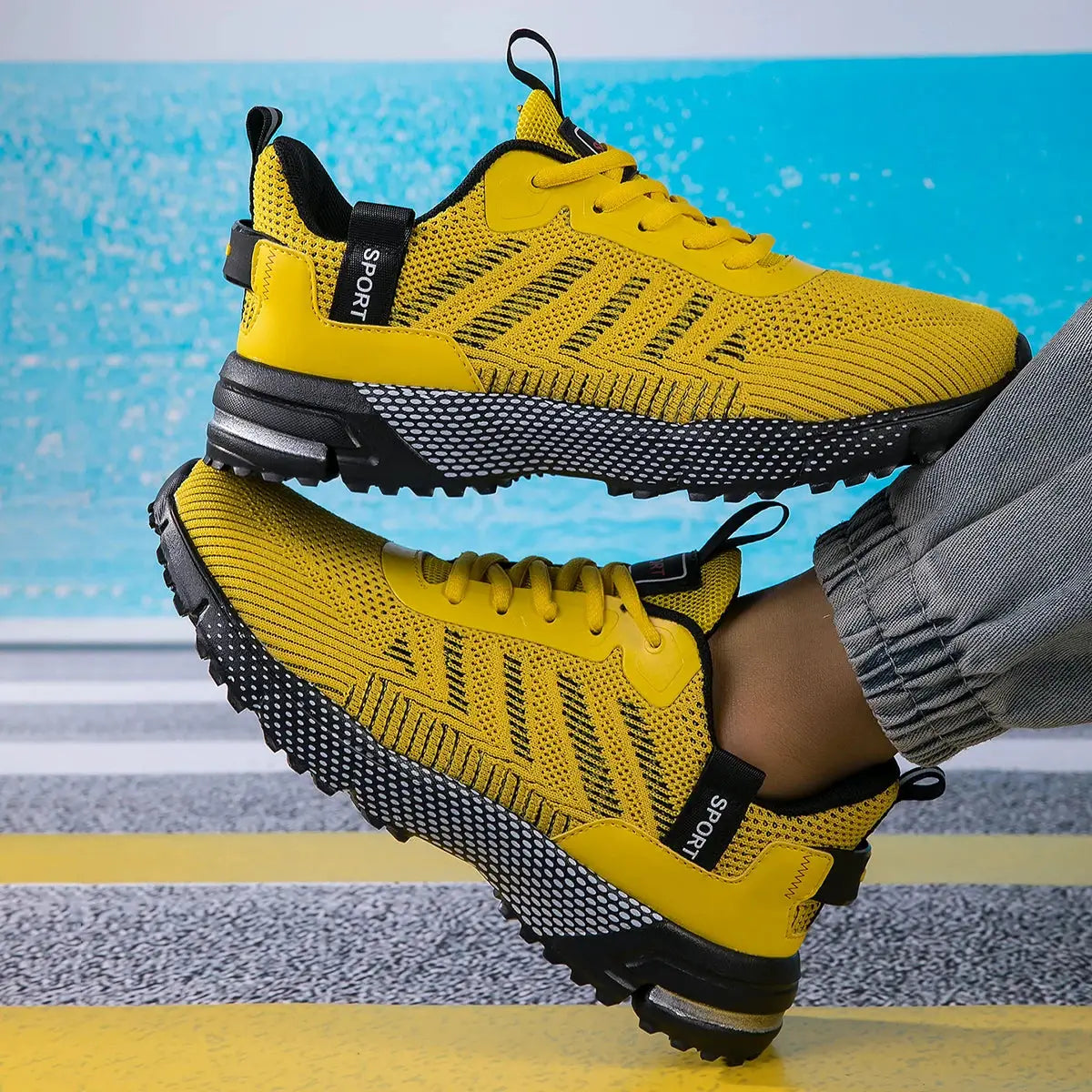Pair of men's yellow running shoes with breathable mesh and lace-up design