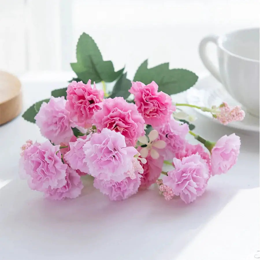 Pink artificial carnation bouquet with green leaves, 15 flower heads, for wedding arch decor or garlands.