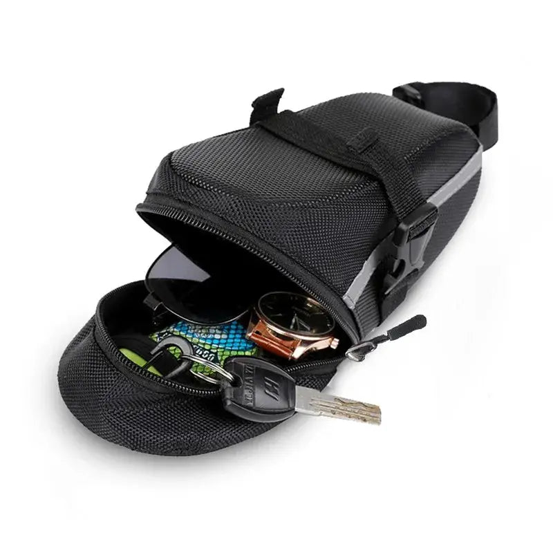 An open waterproof bicycle saddle bag showcasing essentials like sunglasses, keys, and a watch inside.