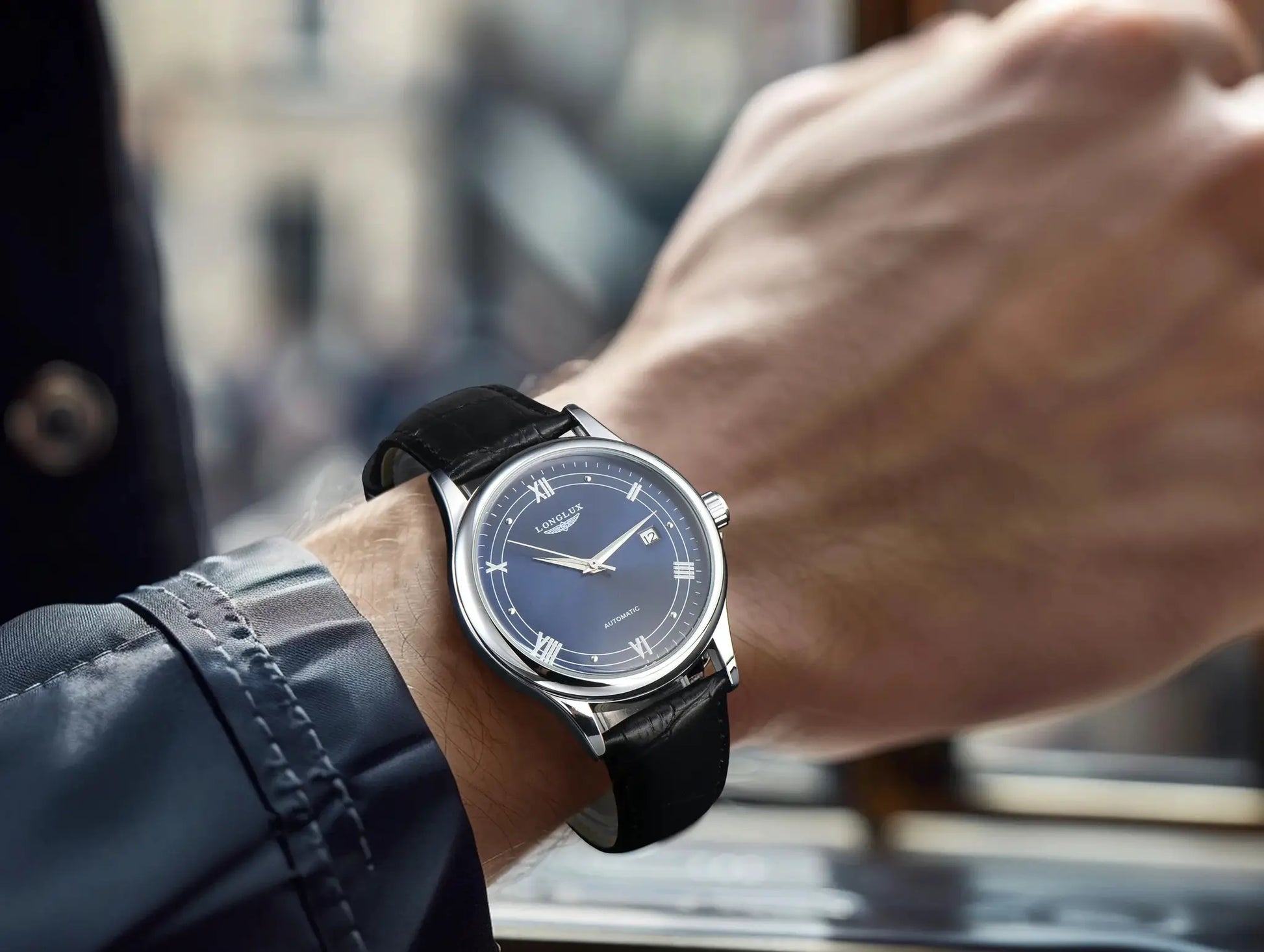 LONGLUX automatic men's wristwatch with blue dial, Roman numerals, date display, and black leather strap.