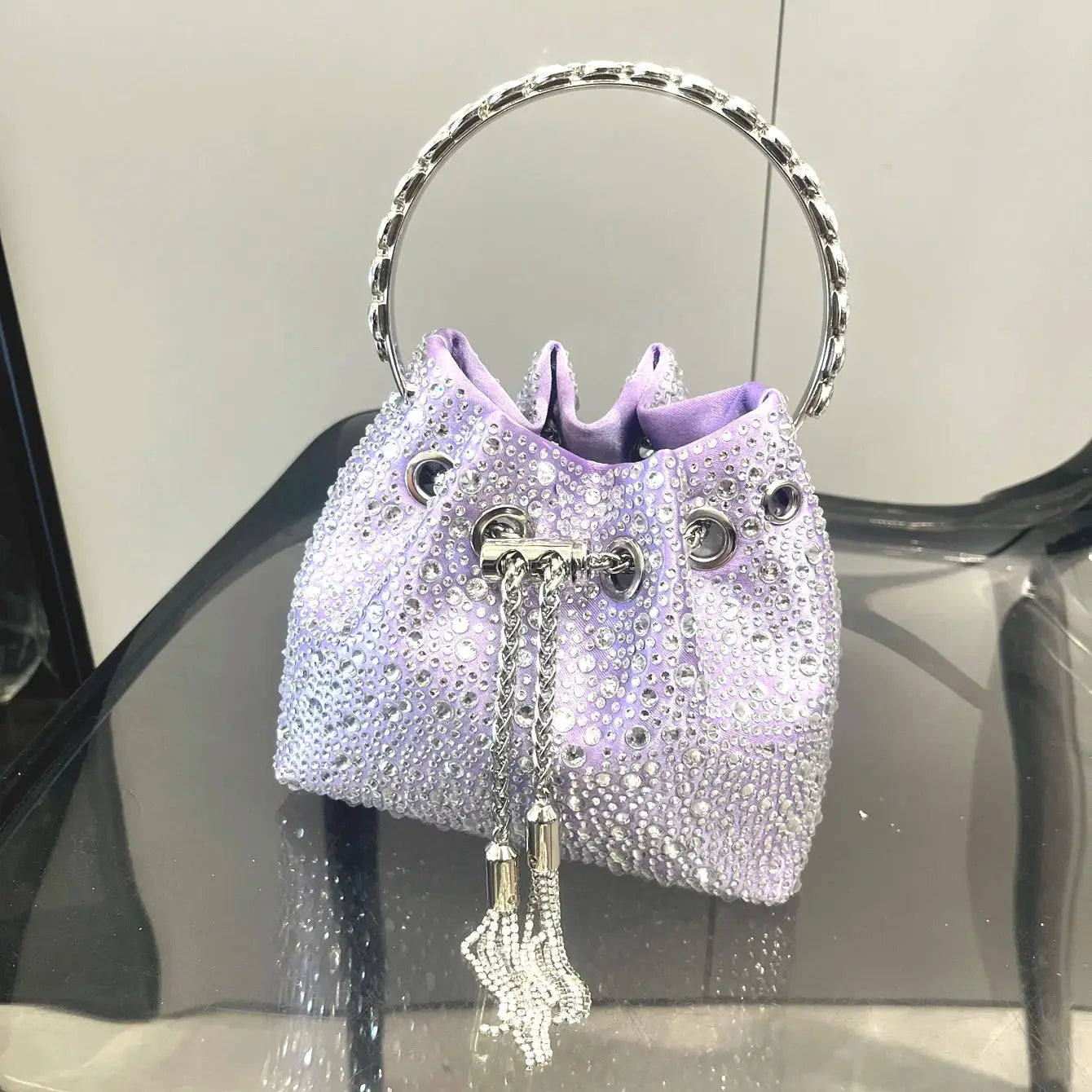 Rhinestone bucket bag in purple with silver ring handle and tassel drawstrings