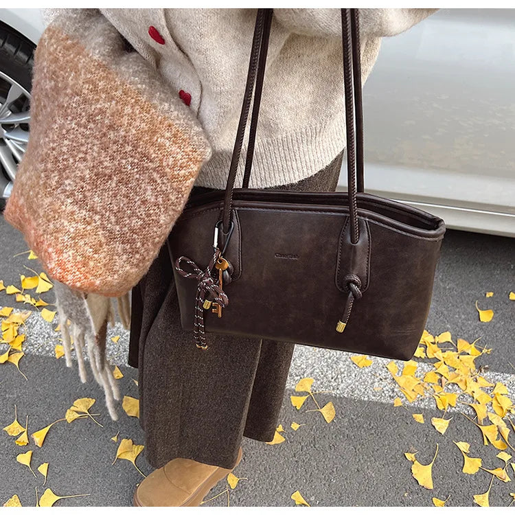 Simples Market PU leather shoulder bag for women in dark brown with dual top handles and a decorative keychain.