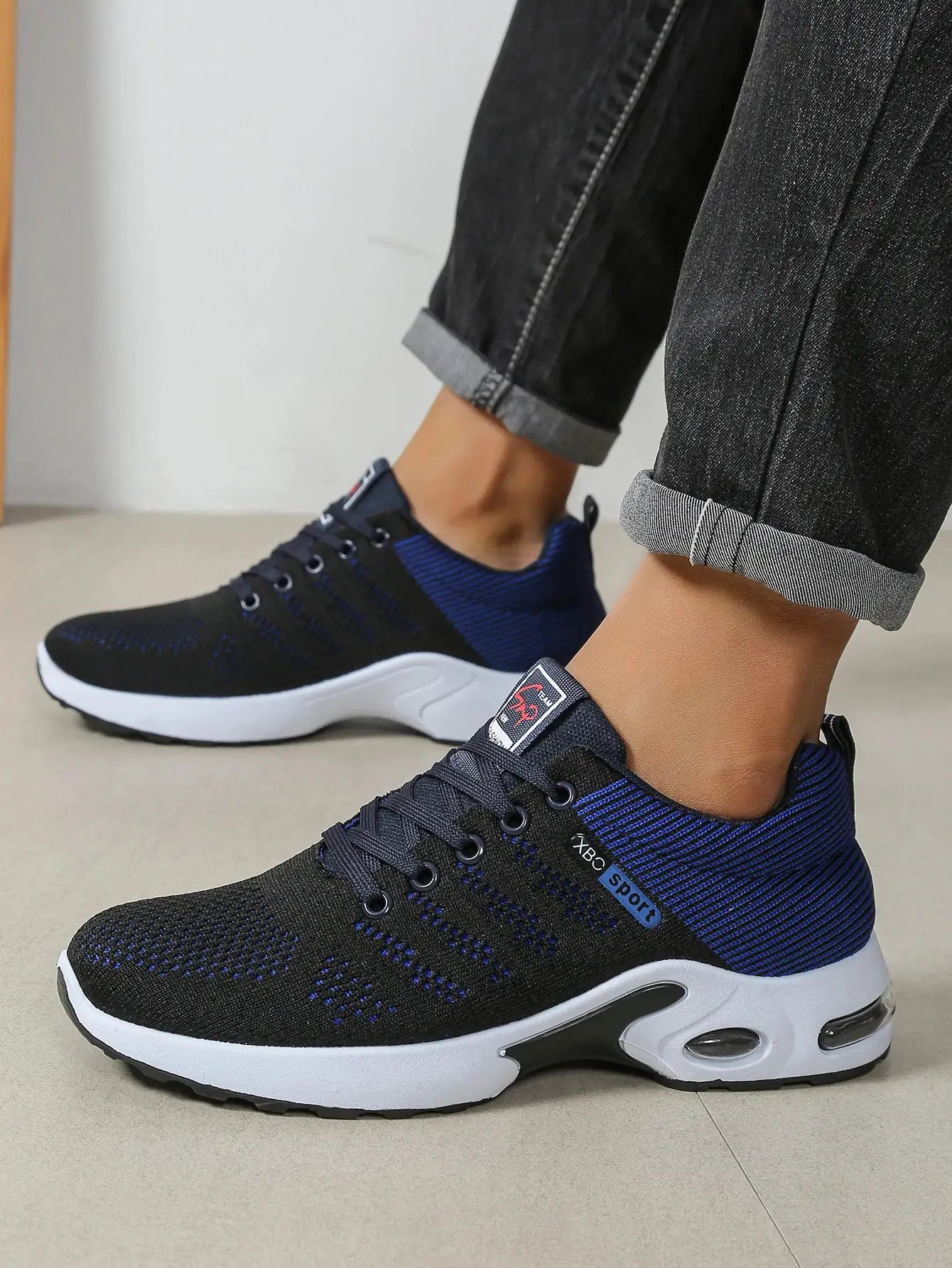 Pair of men's running shoes in black and blue knit with white sole, lace-up design by Simples Market