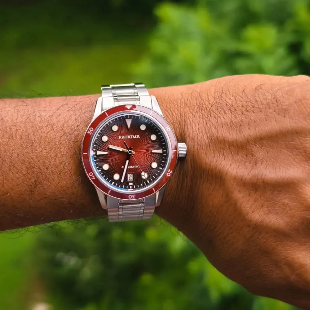 Proxima 39mm dive watch on stainless steel bracelet with red bezel and luminous brown sunburst dial.