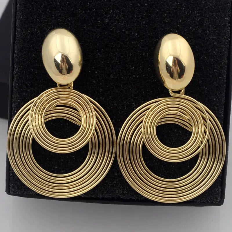 Gold-tone circular hoop earrings with nested concentric rings, large dangle pair