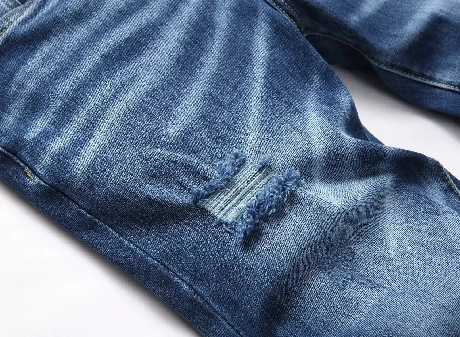 Men's ripped light-blue denim jeans with frayed knee hole, slim fit.