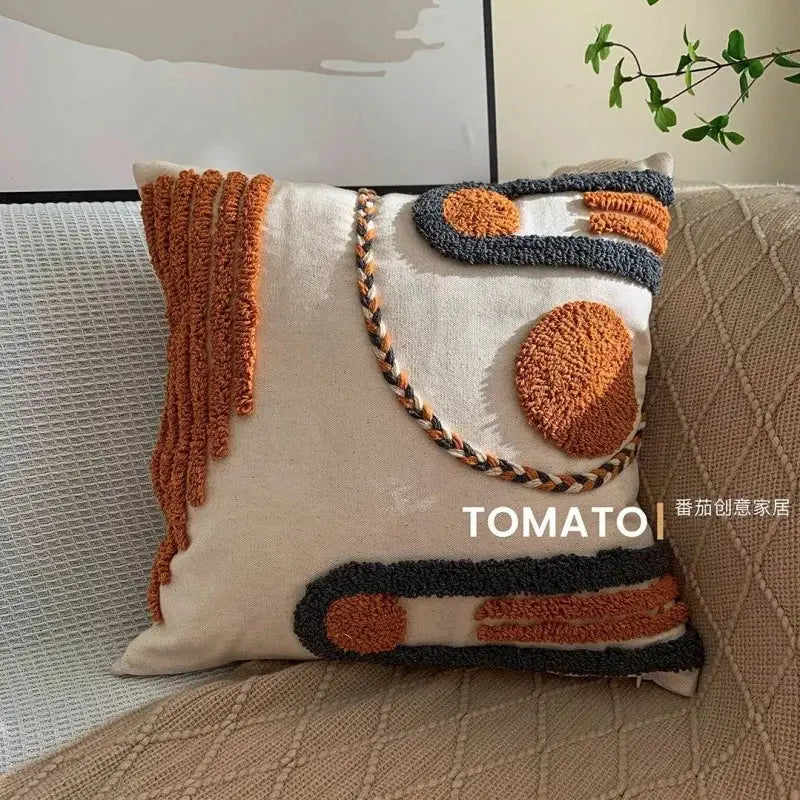Bohemian pillow cushion cover with geometric embroidery and orange tassels on a beige base for living room sofa decor.