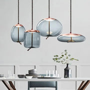Pendant lamp set: blue glass shades with copper tops on hemp rope cords, four minimalist hanging lights.