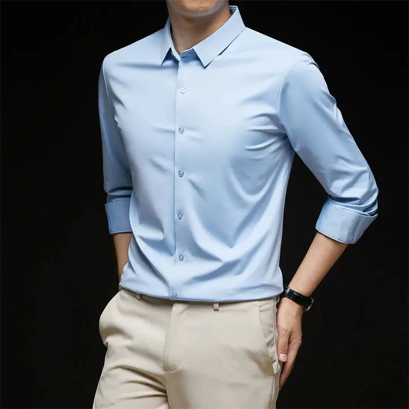 Men's light blue long-sleeve dress shirt with rolled cuffs, paired with beige trousers