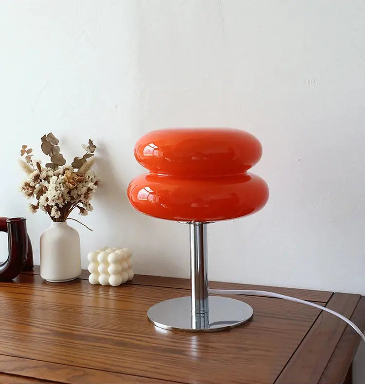 Macaron glass table lamp by Simples Market; orange glossy double-donut shade on chrome base.