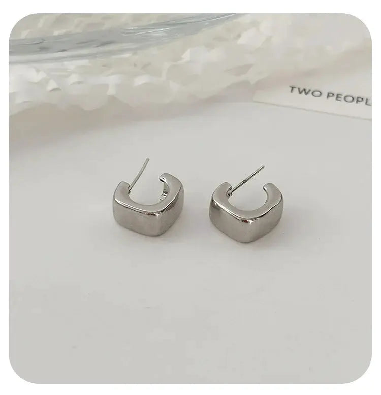 Silver irregular oval stud earrings with thick curved U-shape and post backs