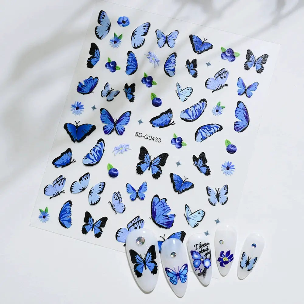 Butterfly nail decals sheet in blue with floral accents; 5 display nails show rhinestones.