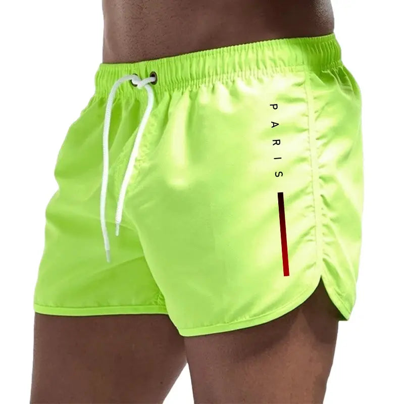 Men's neon green board shorts with white drawstring and Paris graphic
