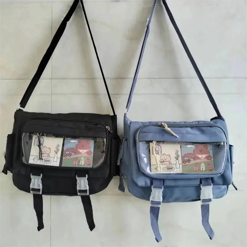 Pair of large-capacity crossbody canvas bags by Simples Market in black and blue, each with clear front pockets.
