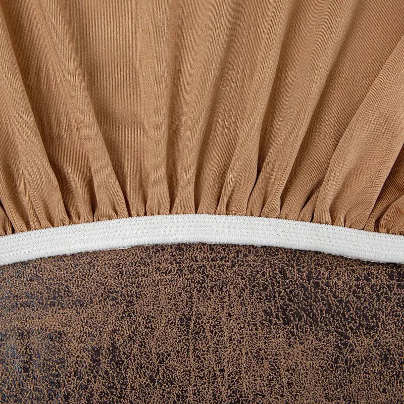 Stretch sofa cover by Simples Market with white elastic edge in tan fabric.