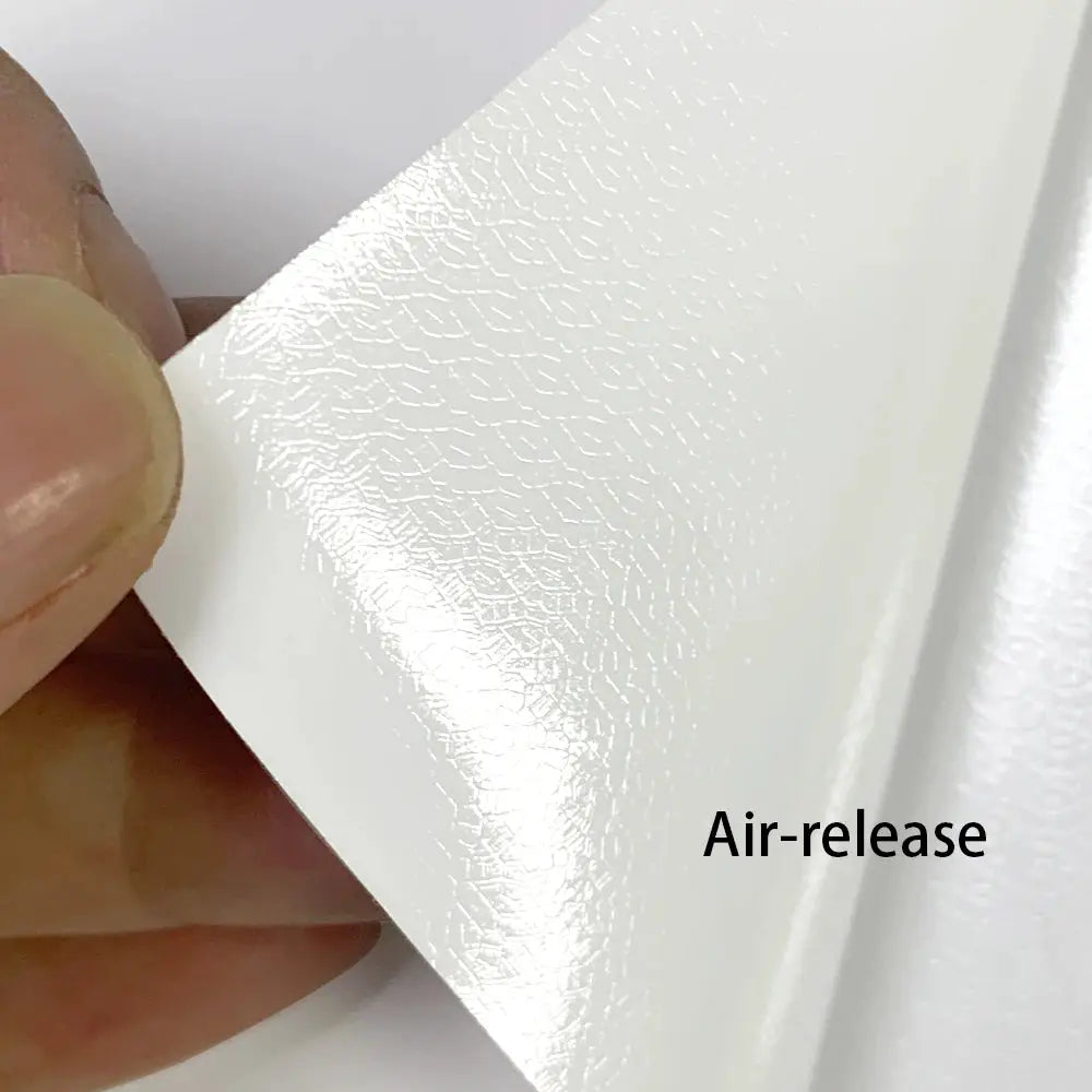 Matte white vinyl car wrap film sheet with air-release backing being peeled