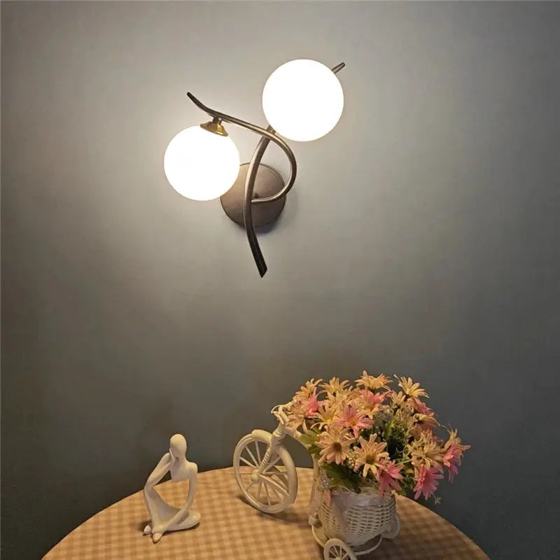 Nordic iron wall lamp with two glass globe LED bulbs, dark metal wall-mounted fixture.