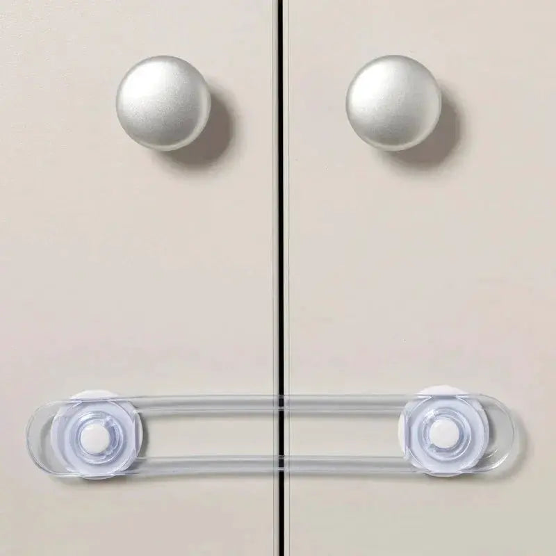 Simples Market transparent child safety lock for drawers and cabinets, clear strap with dual mounting discs securing two cabinet doors.