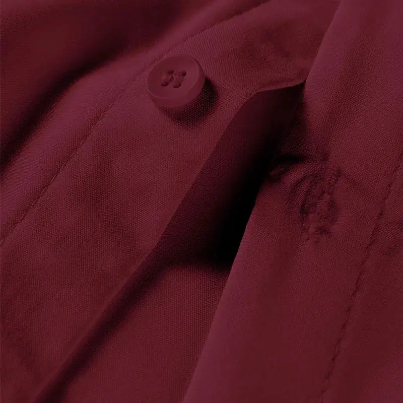 Men's burgundy solid-color short-sleeve shirt fabric close-up with button detail