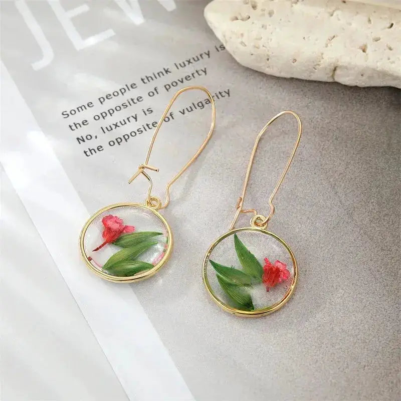 Natural Flower Dangle Earrings; gold-tone bezel with epoxy resin featuring green leaves and pink blossoms