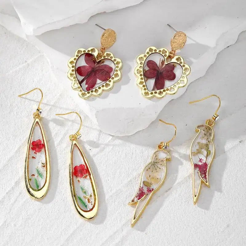 Natural flower dangle earrings; six earrings in three gold-tone epoxy resin designs with colorful pressed petals