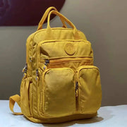 Backpack by Simples Market: yellow waterproof nylon with multiple pockets and soft handles