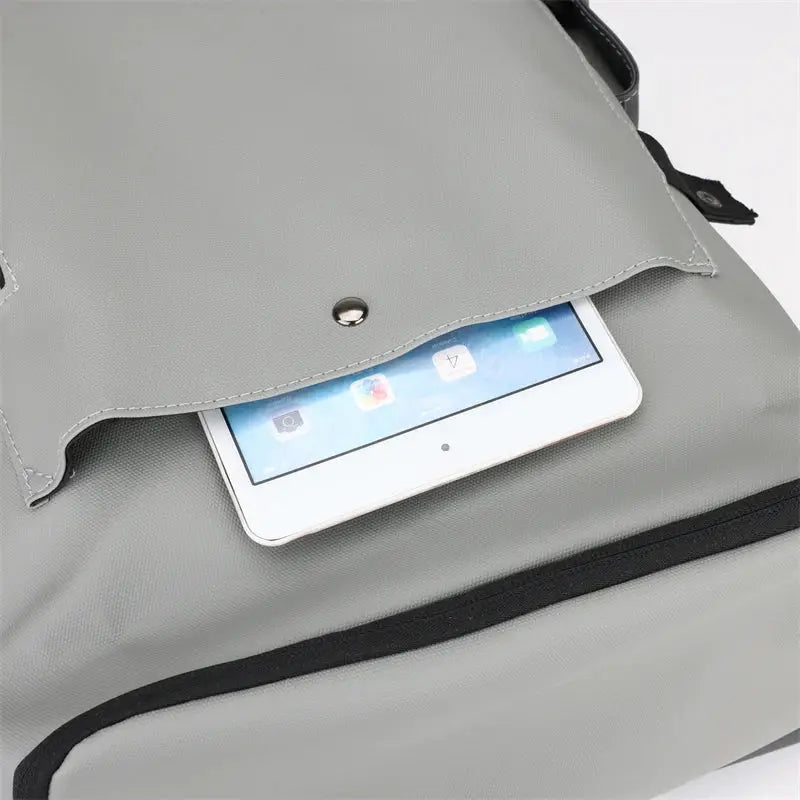 Laptop backpack in gray, waterproof with front pocket and tablet partially visible.