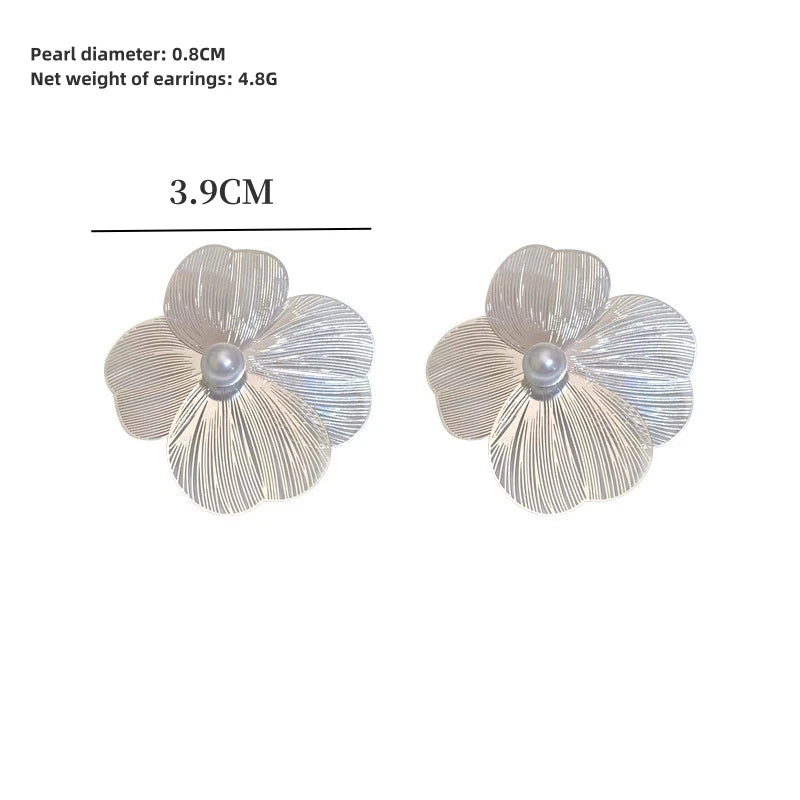 Large flower pearl earrings, pair of silver-tone ribbed petals with central pearl.