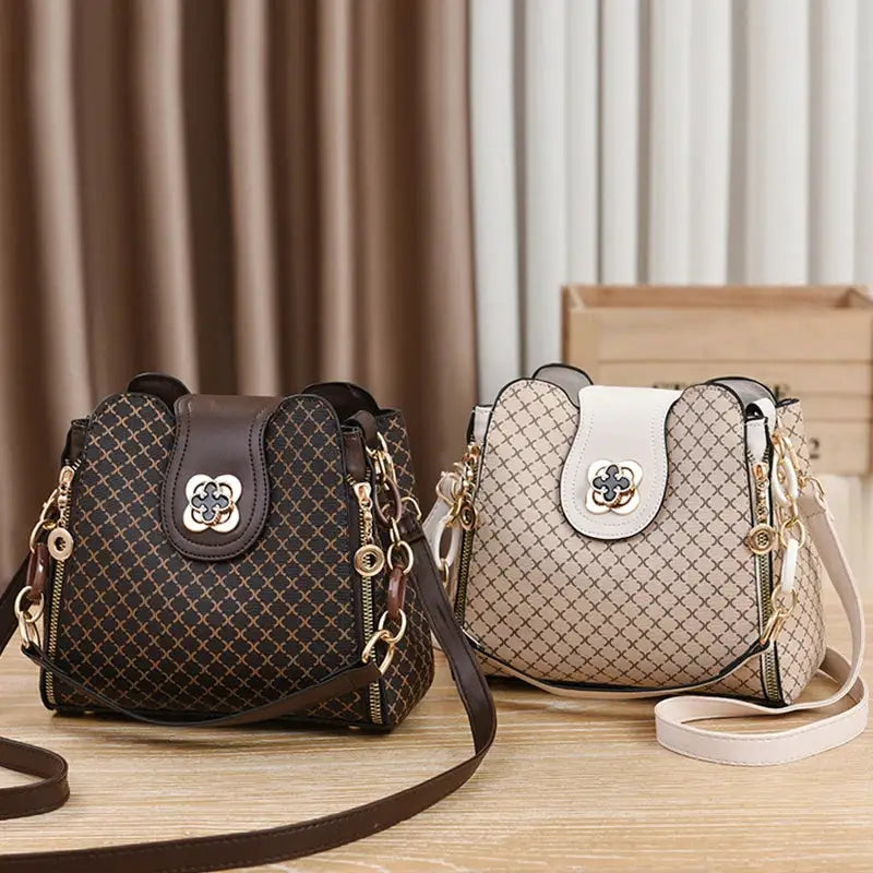 Two Simples Market bucket crossbody handbags in black and beige check patterns with gold hardware.