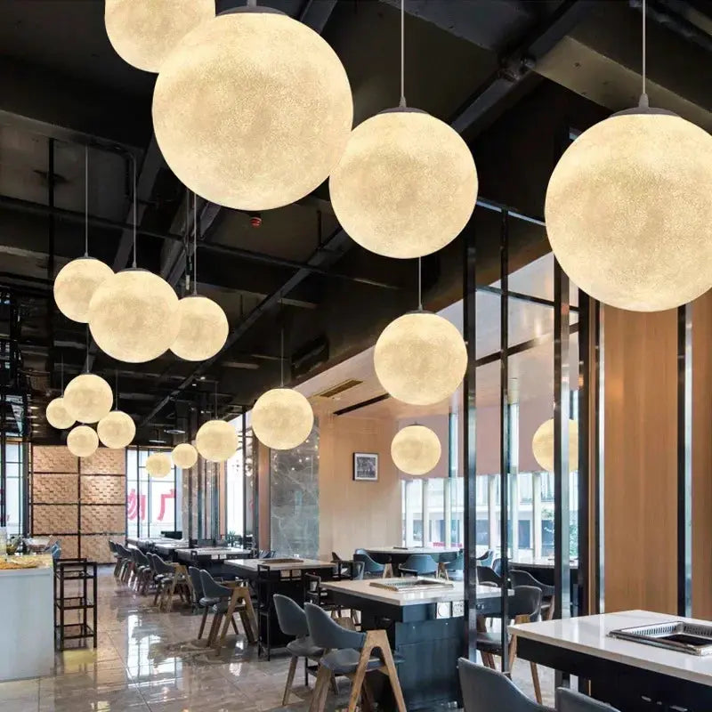 Nordic Moon LED pendant lights by Simples Market; frosted glass globe lamps with warm glow over cafe dining area
