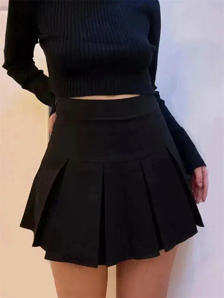 Black high-waist pleated mini skirt paired with a black knit top