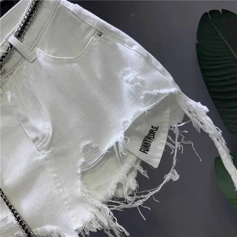 White denim mini skirt with distressed holes, raw hem, and pockets